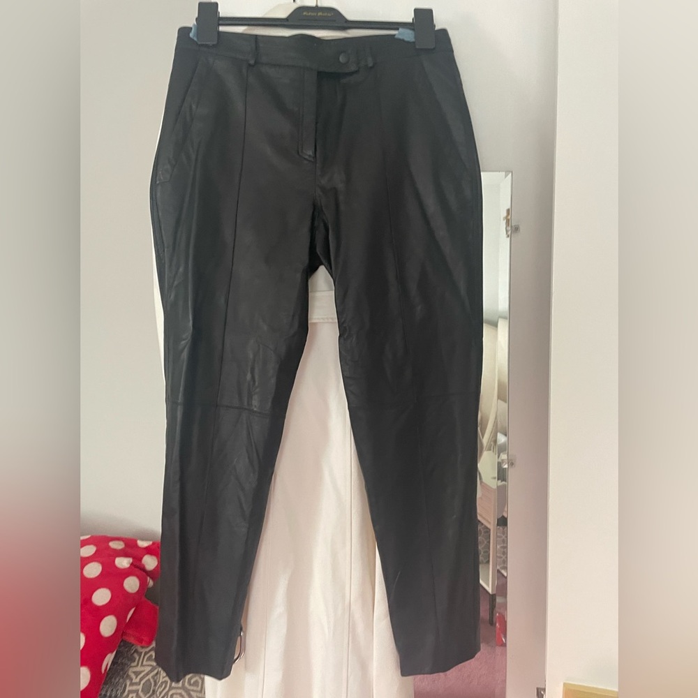 Worn once leather pants. Tapered at ankle. Button and zipper closure